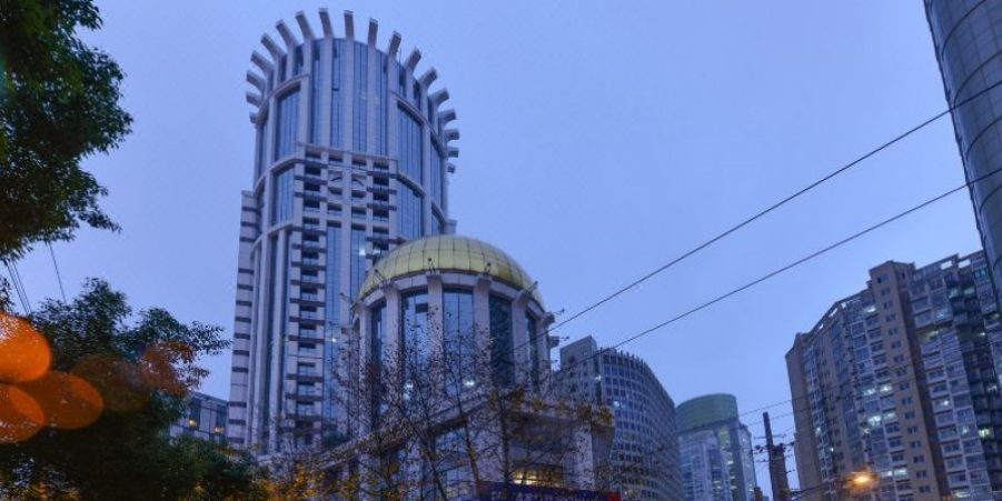 A city skyline showcases a tall building, serving as a central landmark amidst urban surroundings.